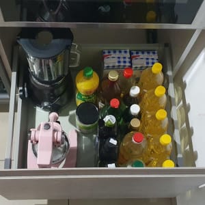 מגירה עם בלנדר, מסחטה ובקבוקי שמן מאורגנים