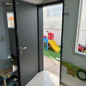 דלת פתוחה מובילה לחצר עם מגלשה צבעונית