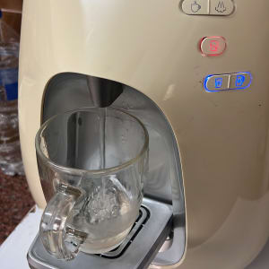 מכונת מים עם כוס זכוכית מתמלאת במים