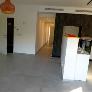 חדר מגורים עם מטבח פתוח ודלת פתוחה