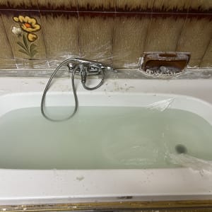 אמבטיה עם מים, ברז ומקלחת יד