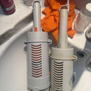 שני חלקי פלסטיק לבנים על כיור עם כפפות כתומות