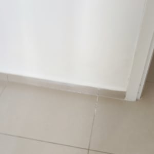 רצפה מרוצפת עם קיר לבן ודלת פתוחה