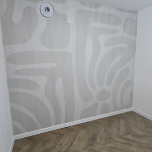 קיר עם טפט דקורטיבי ודוגמת עץ על הרצפה