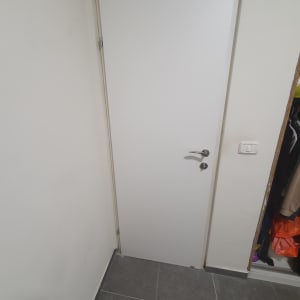 דלת לבנה עם ידית כסופה ומנעול