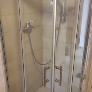 מקלחון זכוכית עם דלתות ומקלחת יד