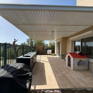פרגולה מאלומיניום מעל מרפסת עם ריהוט גן