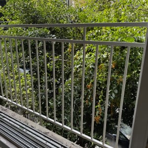 מעקה מתכת לבן עם מסגרת חלון בצד