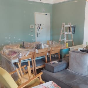 צביעת קיר בסלון מרוהט עם כיסוי הרהיטים בניילון הגנה