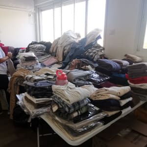 בגדים מקופלים ומסודרים על שולחן בחדר מואר