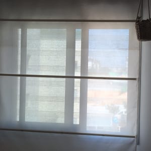 וילון גלילה על חלון עם שעון קיר