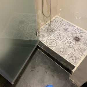 מקלחון עם רצפה מעוצבת ומגבת כחולה