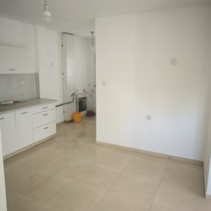 חדר ריק עם קירות לבנים ורצפת אריחים