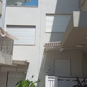 אדם יושב ליד דלי צבע וכלי עבודה לאיטום