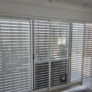 תריסי אלומיניום בחלון גדול בחדר פנימי