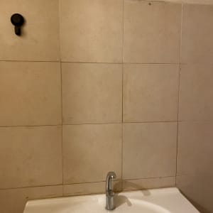 כיור רחצה צמוד לקיר מחופה אריחים עם פס איטום סיליקון