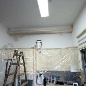 עבודות הכנה וצביעה במטבח מרוהט עם כיסוי ניילון להגנה