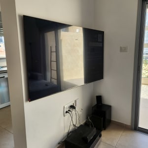 טלוויזיה תלויה על הקיר עם כבלים מחוברים