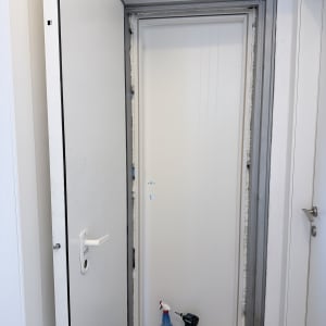 התקנת דלת פנים לבנה בתוך משקוף פלדה של ממ"ד