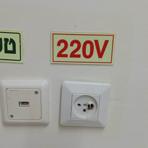 שקע חשמל עם תווית 220V על קיר