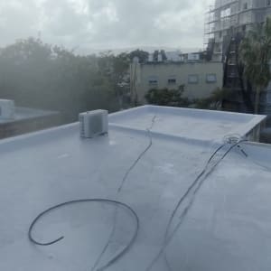 גג אטום עם מזגנים וחוטים, ללא אנשים או טקסט.