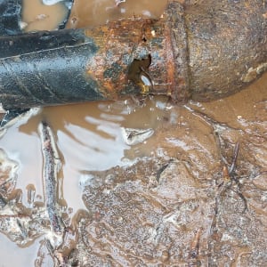 צינור חלוד עם נזילה בבוץ