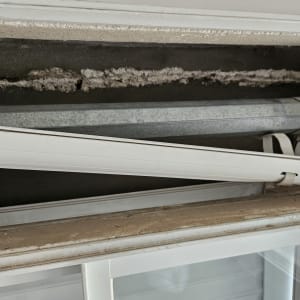 תריסים לבנים עם מנגנון גלילה חשוף