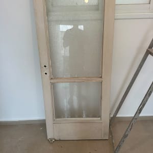 דלת עץ עם זכוכית מעוצבת העומדת במהלך עבודת תיקון או החלפת זכוכית