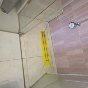 בדיקת נזילה במקלחת עם צבע צהוב ומד לחץ