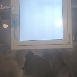 חלון עם מסגרת אלומיניום על קיר אפור