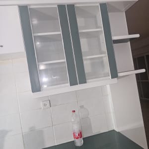 ארון מטבח עם דלתות זכוכית ובקבוק על השיש