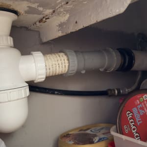 צינור פלסטיק לבן עם מחבר מתחת לכיור