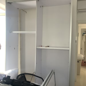 ארון פתוח עם מדפים וכלים על המיטה