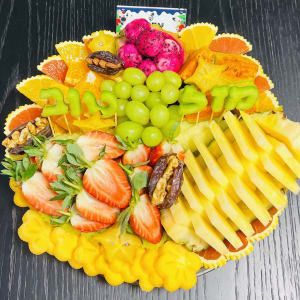 מגש פירות חתוכים עם תותים, ענבים ותמרים