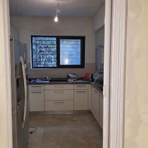 דלת מתקפלת בכניסה למטבח עם מקרר וחלון