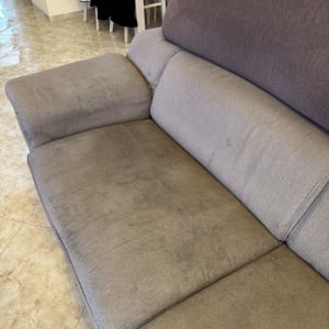 ספה אפורה עם כתמים על המושב והמשענת