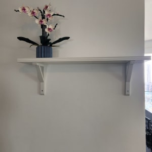 מדף לבן מותקן על קיר עם תומכים