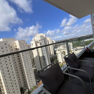 מרפסת עם נוף לבניינים ושמים כחולים