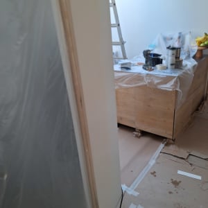 סולם וחפצים מכוסים בניילון בחדר צבוע