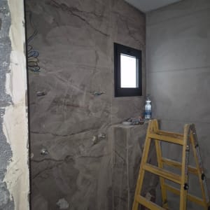 סולם בחדר עם קיר שיש וחלון קטן