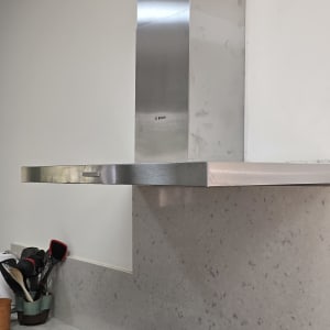 כיריים ומנדף במטבח עם כלים על השיש