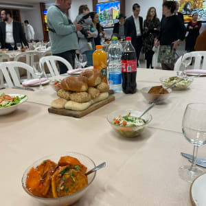 קערות סלטים, לחמניות, בקבוקי שתייה על שולחן קייטרינג