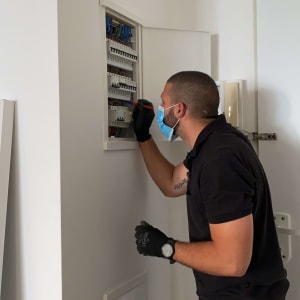 חשמלאי עובד על לוח חשמל עם מברג