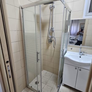 מקלחון זכוכית בחדר אמבטיה עם כיור