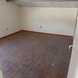 חדר ריק עם רצפת עץ ותקרה נמוכה