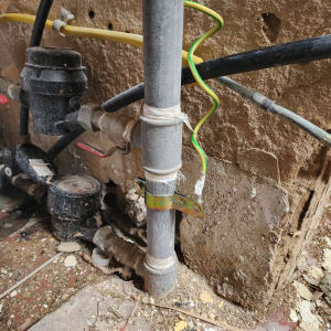 צינור מתכת עם חוטי חשמל צהוב-ירוק מחוברים