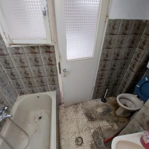 חדר אמבטיה עם קירות אריחים, דלת וחלון
