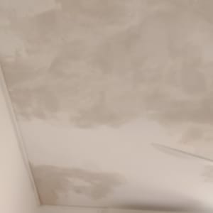 תקרה עם סימני צבע ותיקונים ליד מזגן