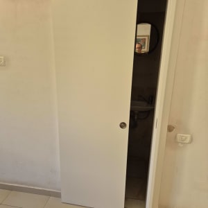 דלת הזזה לבנה עם ידית עגולה