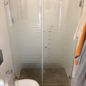 מקלחון זכוכית עם דלתות שקופות ותליית מגבות